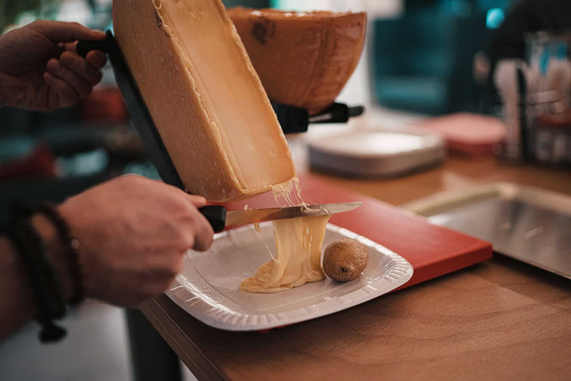 Stieranie roztopeného raclette syra na zemiaky